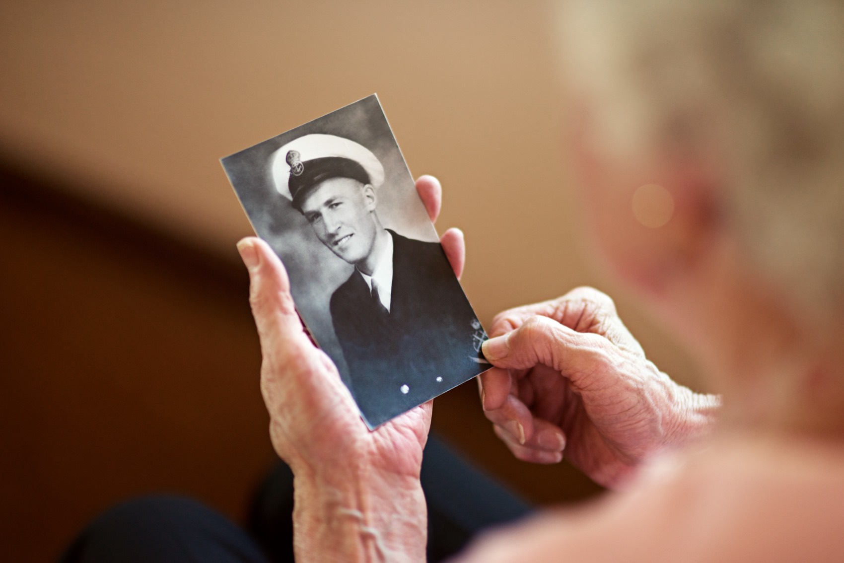 A senior looks at a photo of a young man in uniform